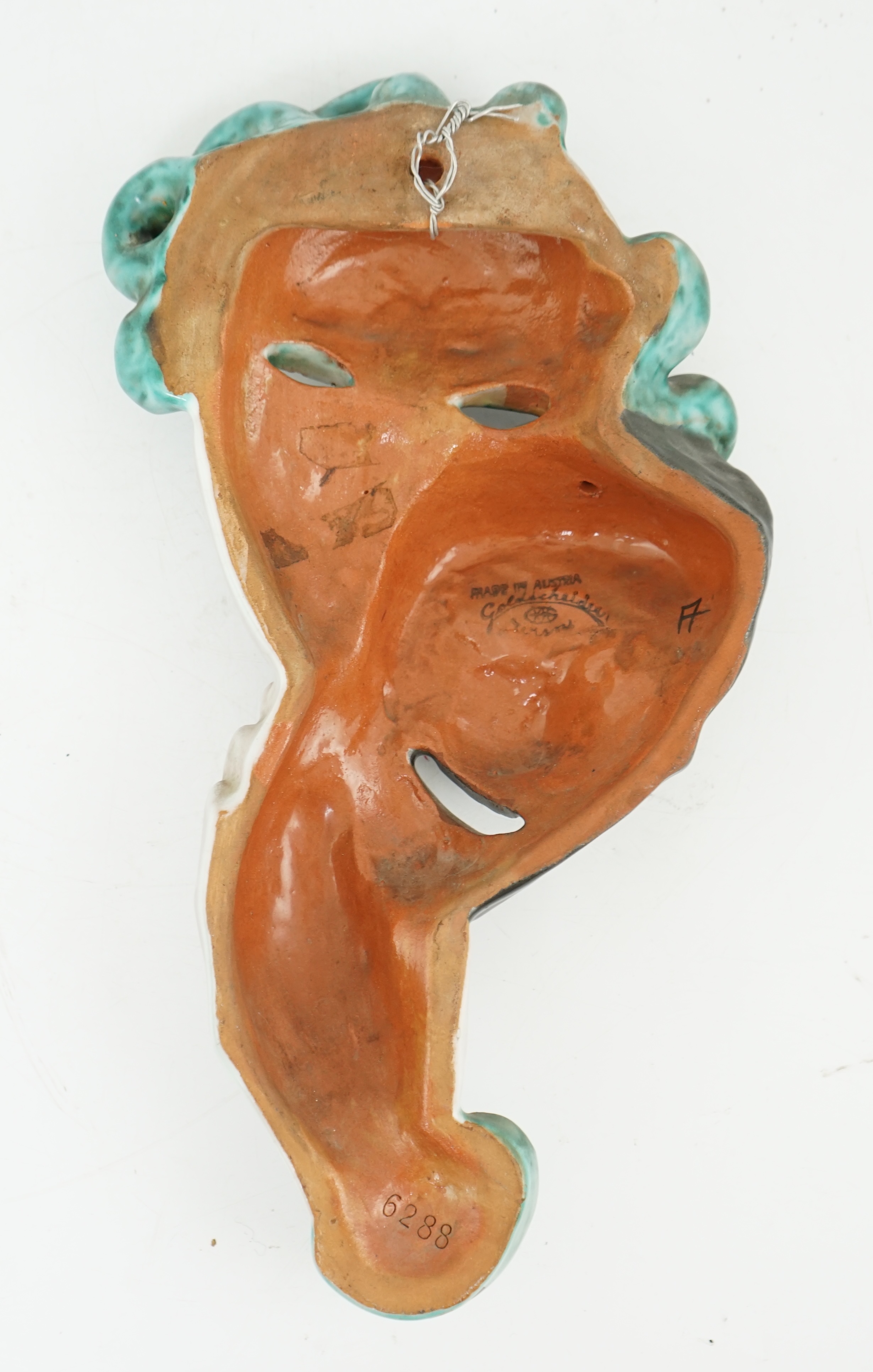 An Art Deco tin-glazed terracotta theatrical wall mask, by Goldscheider